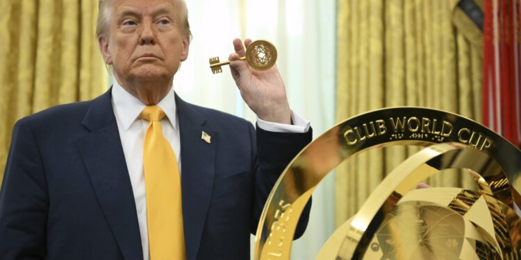 President Donald Trump holding the key to unlock the new FIFA Club World Cup trophy