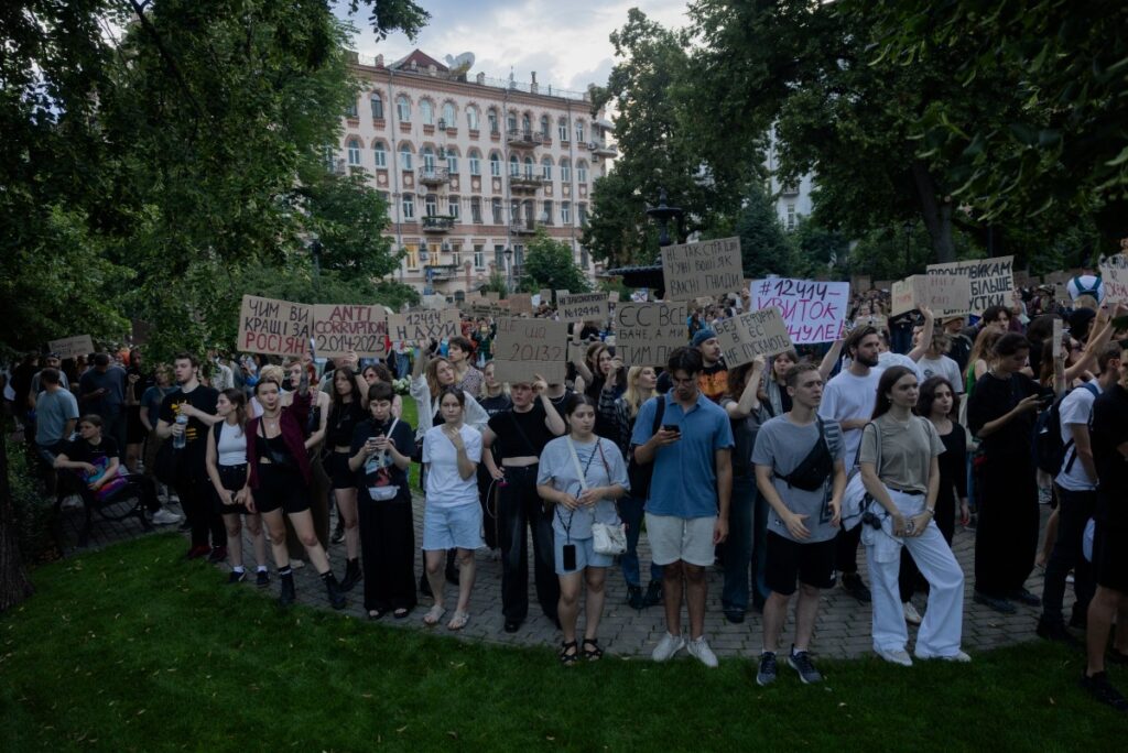 Protesters hold placards during a demonstration calling for the Ukrainian president to veto a law passed by parliament