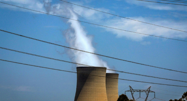 FILES This file photo taken on December 13 2023 shows electricity lines near emission funnels for