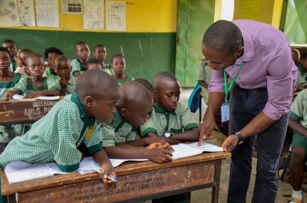 A Nigerian Teacher with his pupils