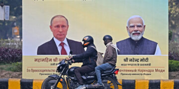 Putin Arrives in India to Strengthen Defence Partnership Amid US Pressure Over Oil Purchases Commuters move past a hoarding with portraits of Russia’s President Vladimir Putin (L) and India’s Prime Minister Narendra Modi in New Delhi.