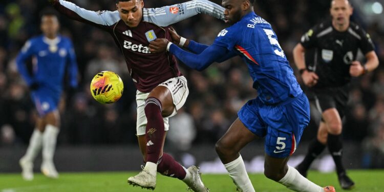 Aston Villa's English striker, Ollie Watkins (L) clashes with Chelsea's French defender, Benoit Badiashile, during the English Premier League football match between Chelsea and Aston Villa at Stamford Bridge.