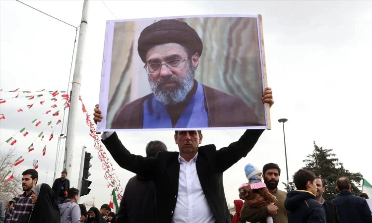 A man holding an image of Mojtaba Khamenei