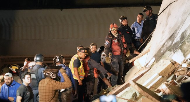 Rescuers work on the remains of a collapsed building following an earthquake in Caracas on June 24